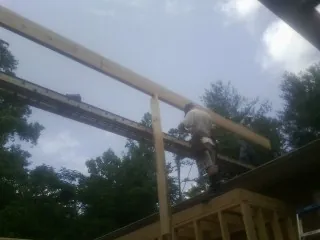 Carpenter setting a ridge beam over a new addition frame — Ice Dam Removal by Roofing Brothers in Buffalo Grove