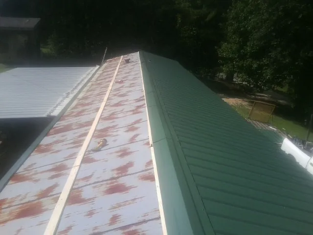 Old rusted panels beside newly installed green metal roofing — Wind Damage Roof Repair by Roofing Brothers in Buffalo Grove