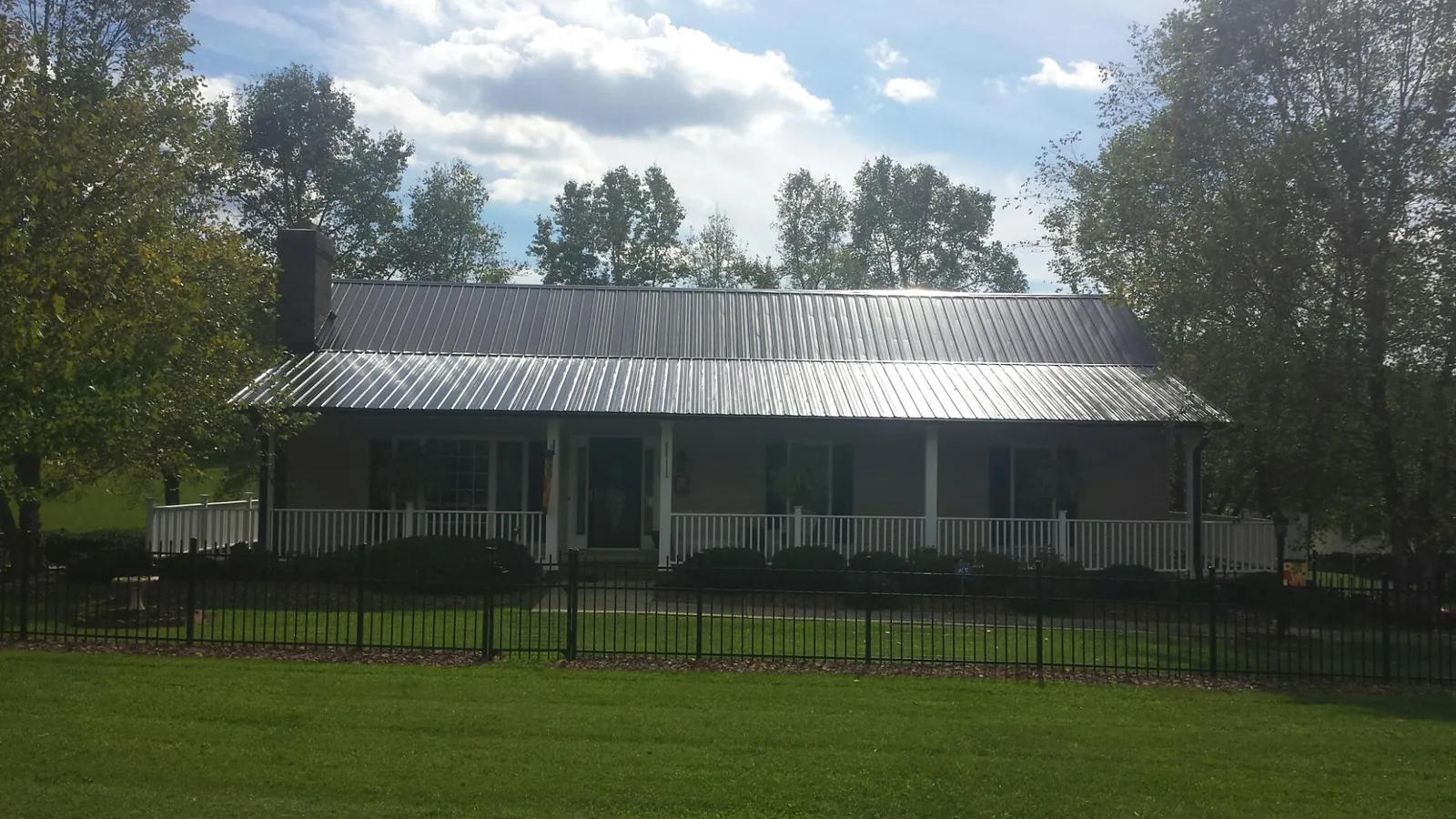 Gray metal roof on a brick ranch with a full width front porch — Gutter Guard Installation work by our crew in Buffalo Grove